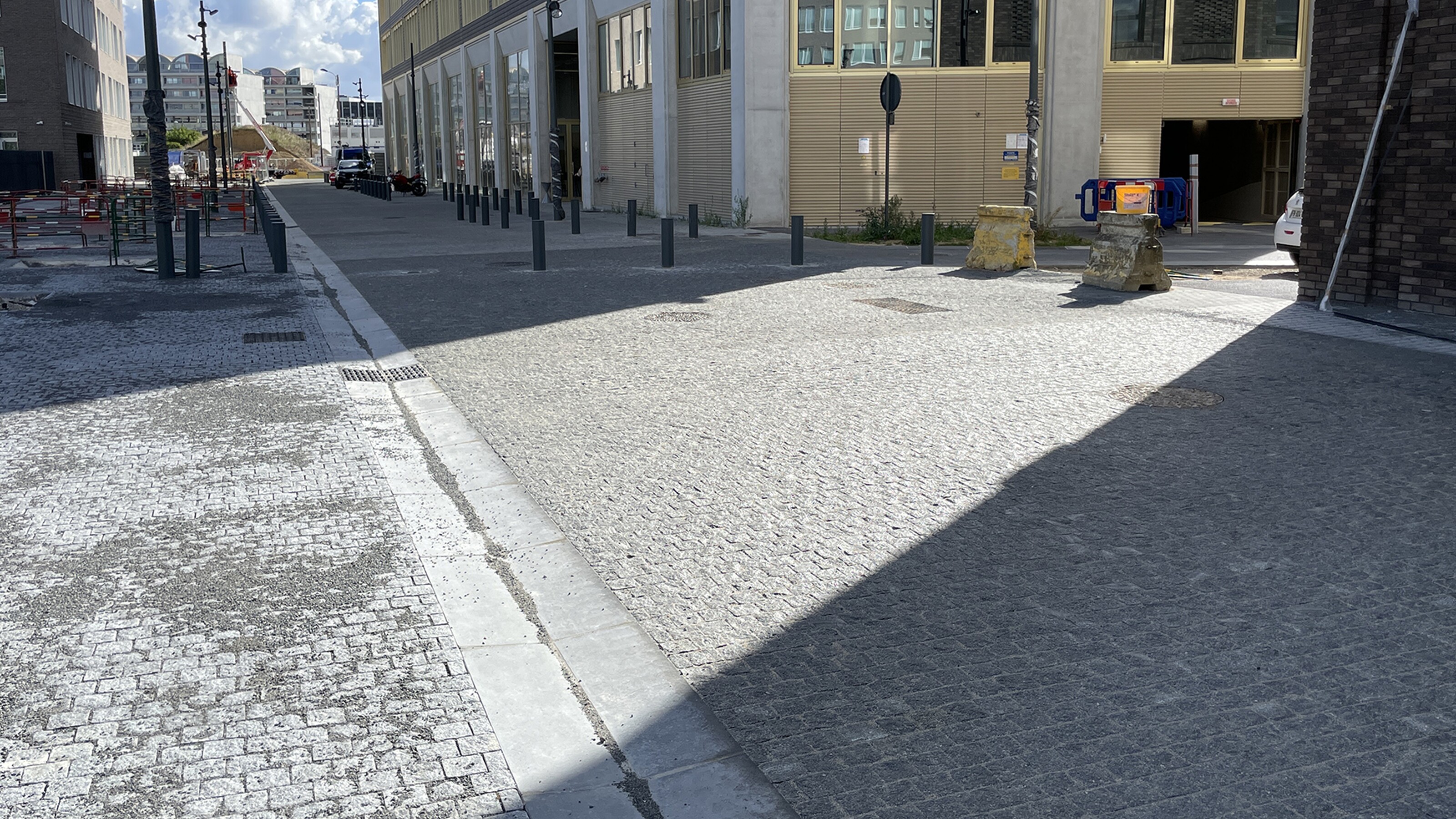 Straat met zebrapad en trottoir tussen hoge gebouwen, zon en schaduw