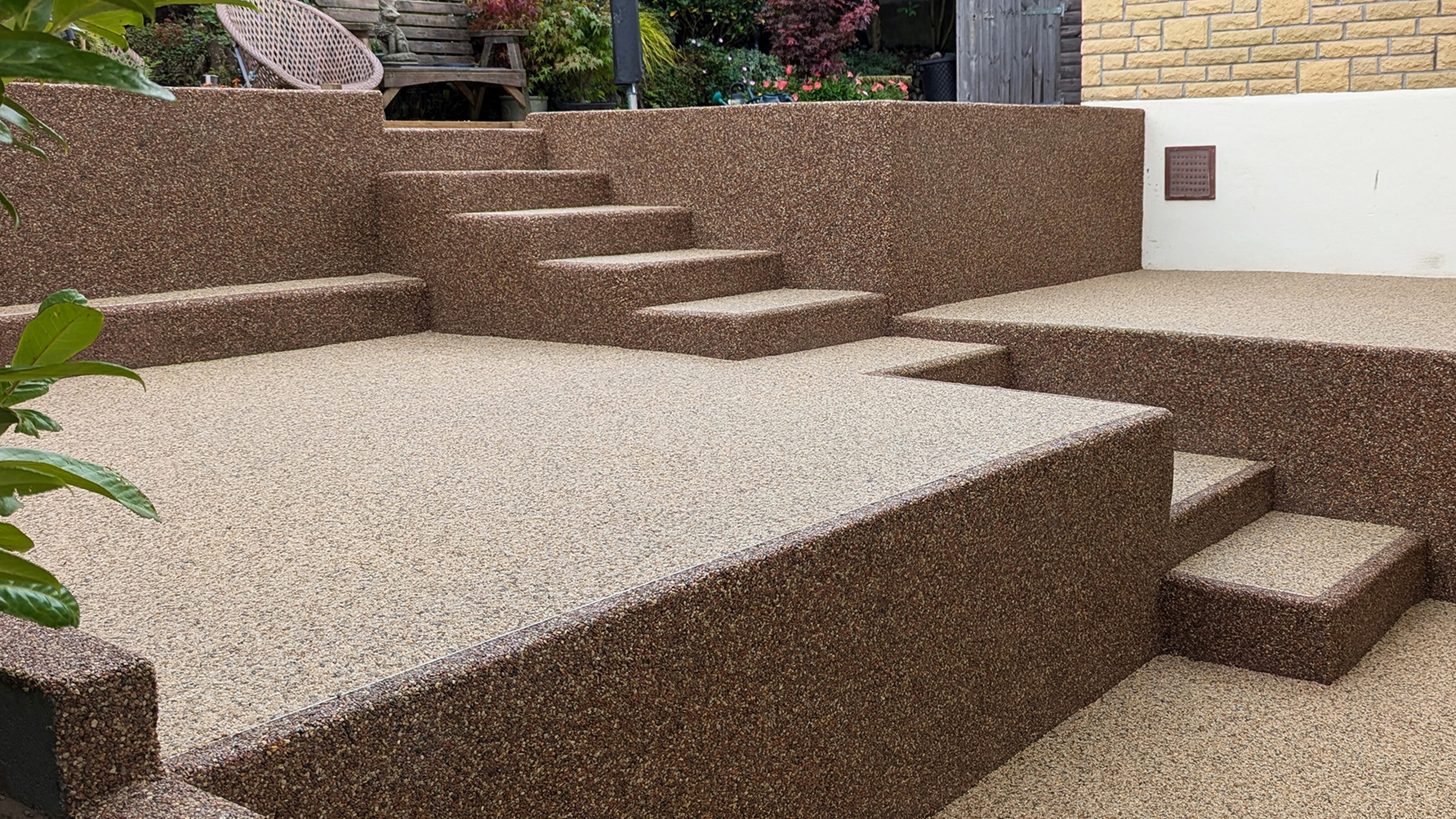 Bruin terras met trappen en groene planten in een tuin