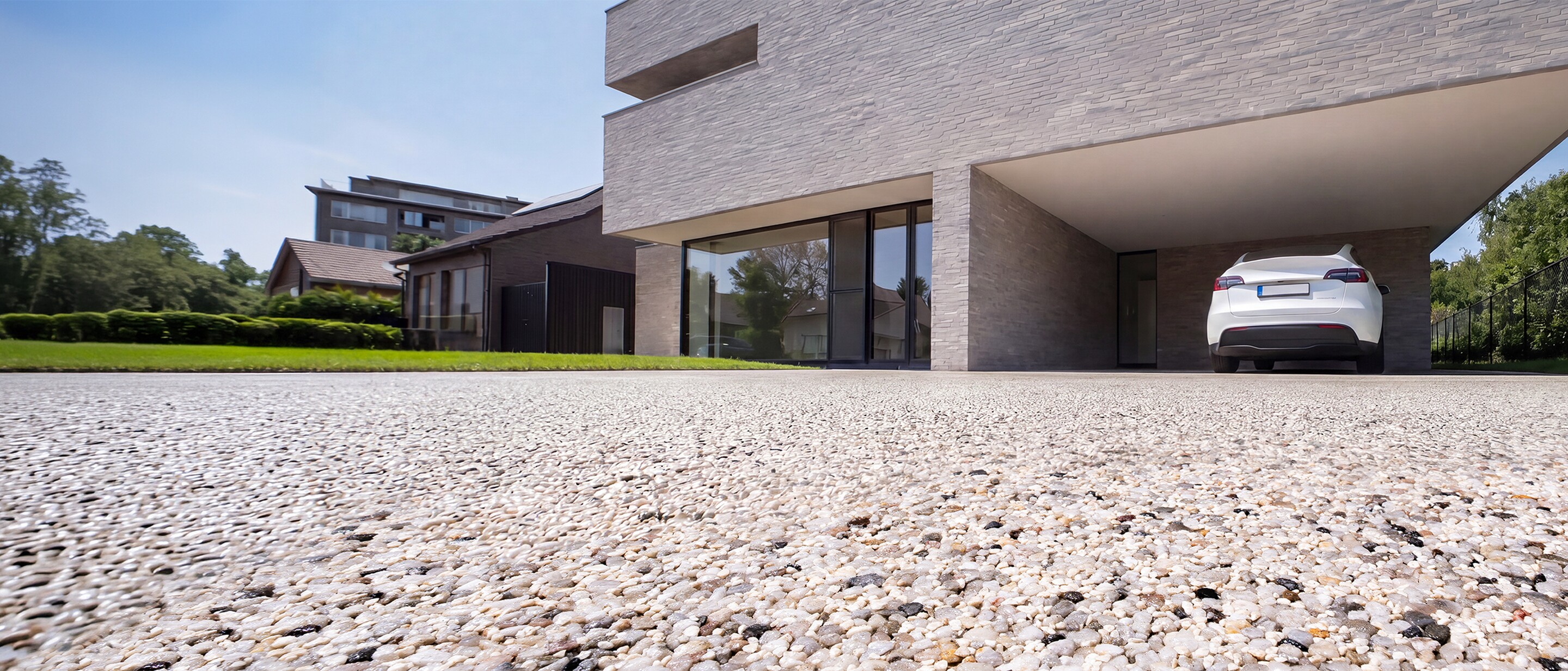Modern building with open passage, viewed from low angle over gravel courtyard