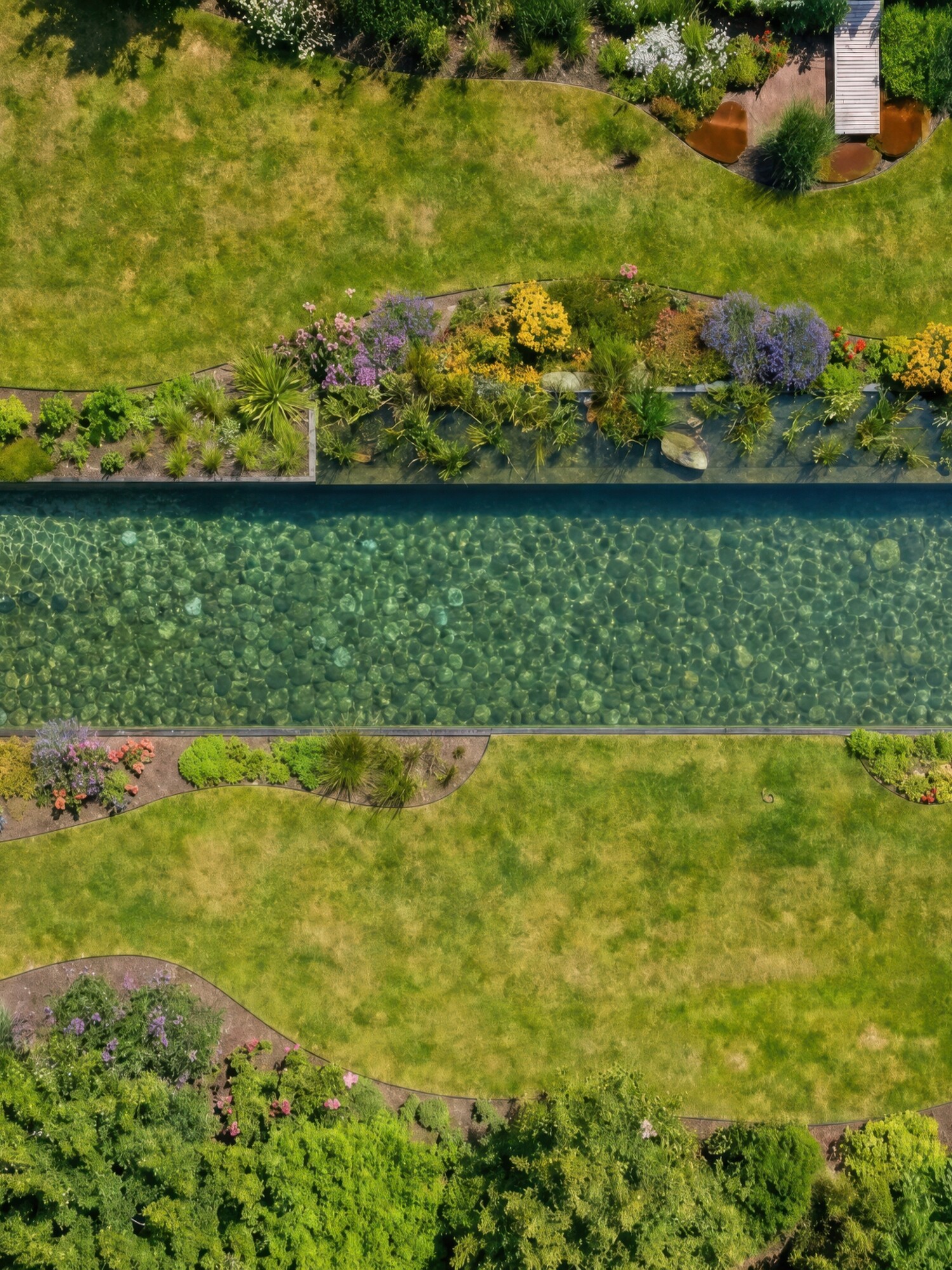 Luchtfoto van groene tuin met lang rechthoekig zwembad en omliggende struiken