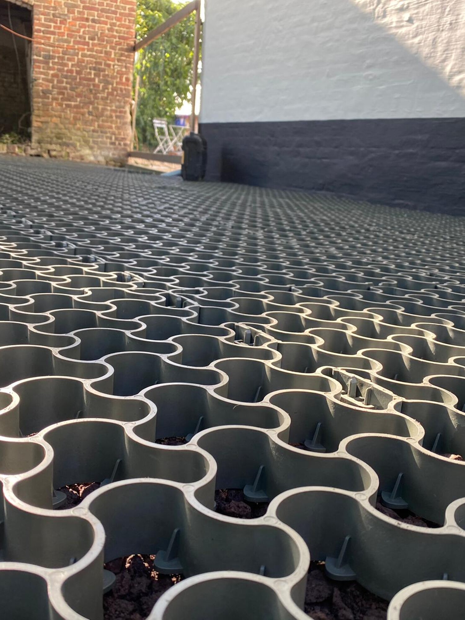 Close-up of interlocking grey paving grid on a driveway in sunlight