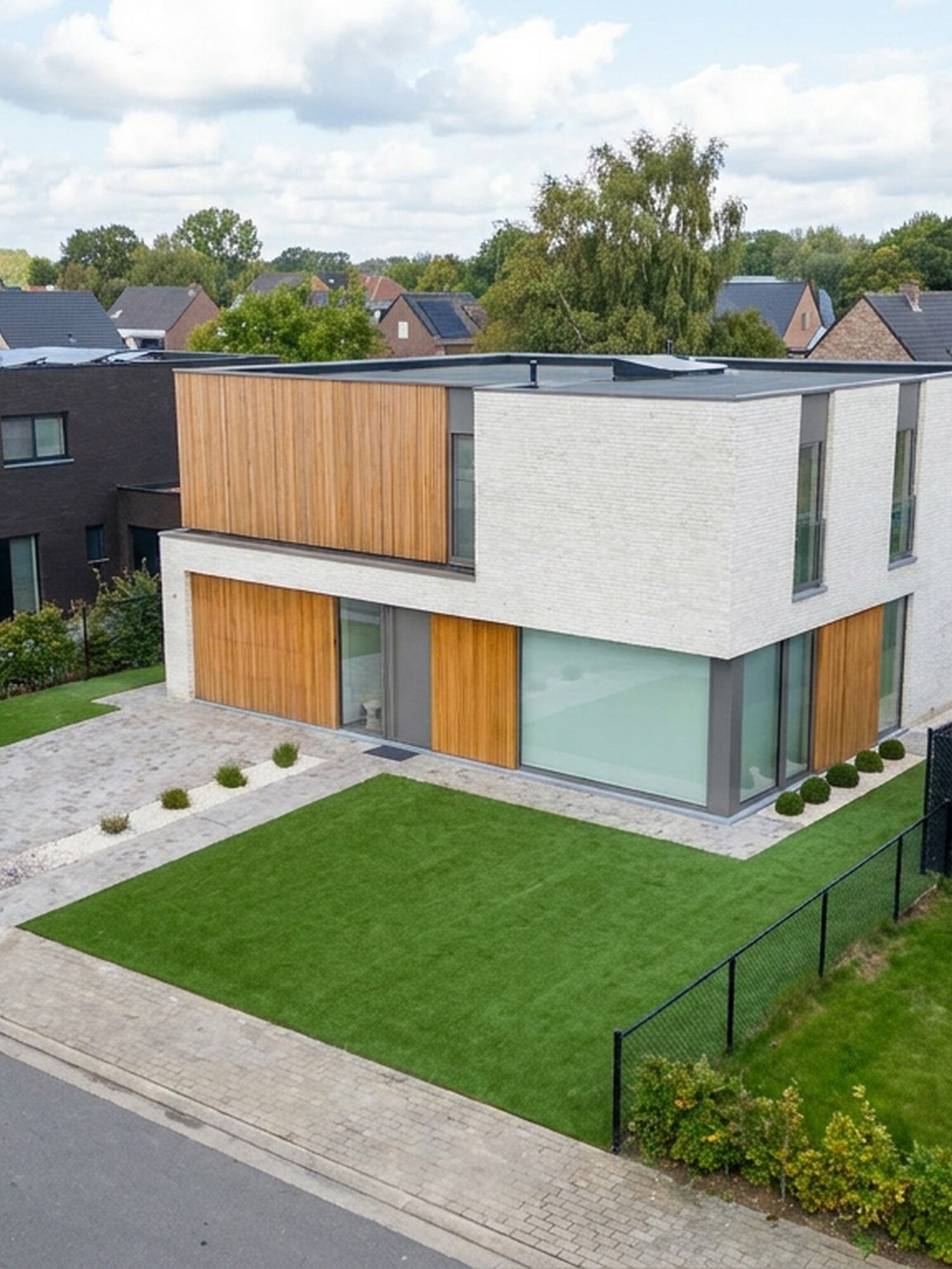 Moderne witte woning met houten accenten in rustige woonwijk, gezien van bovenaf