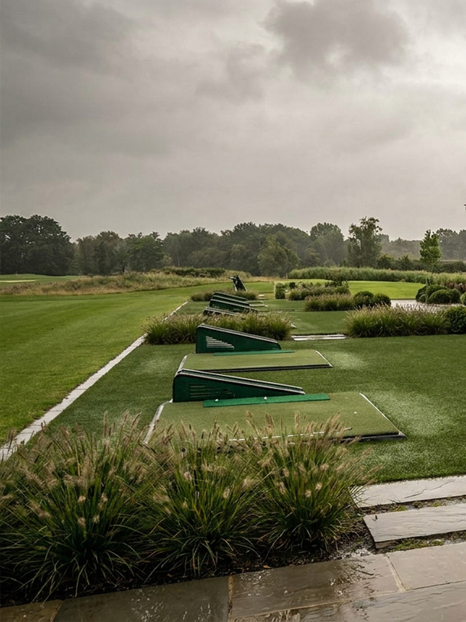 Moderne woning met grote overkapping aan een regenachtig terras en groene tuin