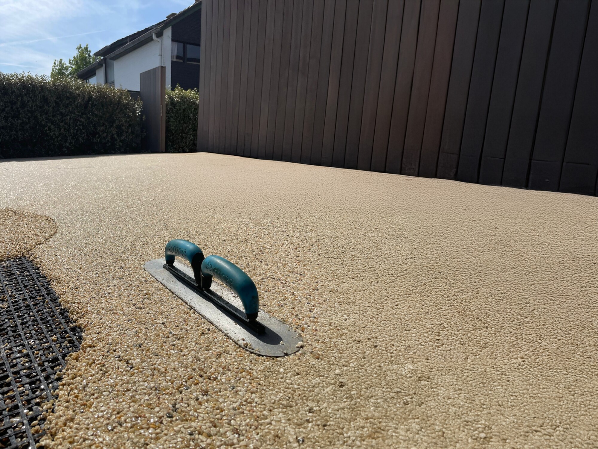 Bloc de ponçage sur une surface en béton beige texturé près d’un mur sombre